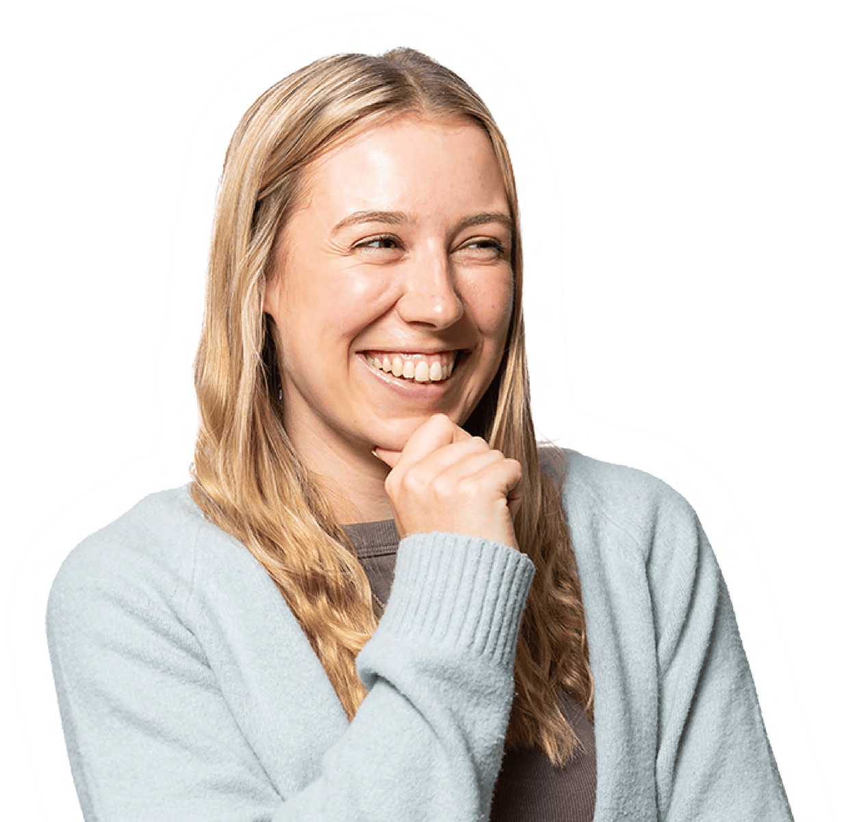 Blonde woman smiling, hand on chin, wearing a sweater.