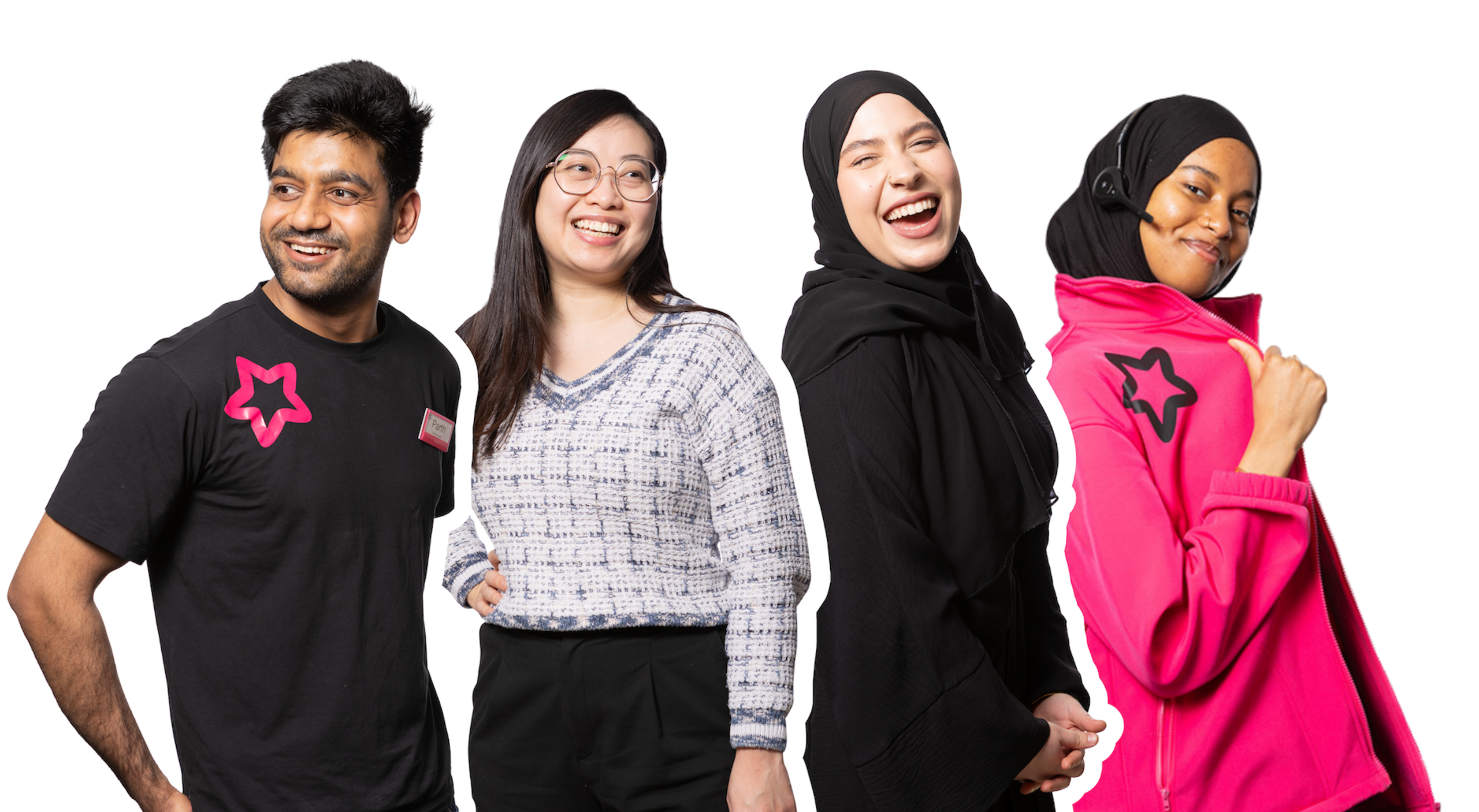 A group of four people of diverse ethnicities and genders smiling and looking in different directions. One man wears a black shirt with a pink star logo and jeans. A woman wears a patterned sweater and black pants. Another woman wears a black hijab and abaya. The fourth person, also wearing a hijab, is dressed in a bright pink jacket and has a headset on.
