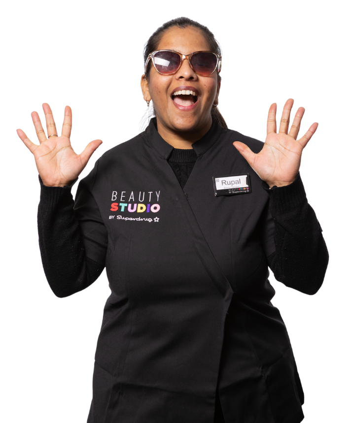 Woman wearing sunglasses and a black uniform with "Beauty Studio" logo, hands raised in excitement.