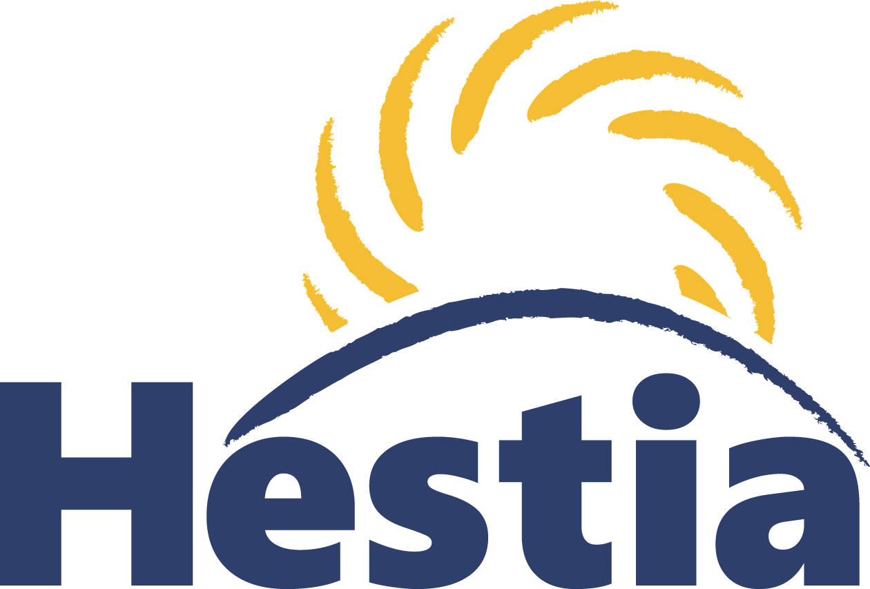 The Hestia logo features the word "Hestia" in large, dark blue sans-serif font. Above the word, a dark blue curved line represents a horizon or arc, with stylized yellow brushstrokes emanating upwards from it, resembling sun rays or a circular motion.